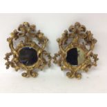 Pair of 19th century Continental gilt gesso wall mirrors in ornate carved frames