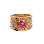 Red stone, gold and diamond ring with an oval cabochon red stone flanked by twelve brilliant cut dia