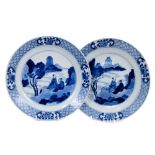 Good pair of Chinese blue and white porcelain dishes, each painted with two figures in a rocky lands
