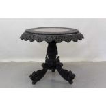 19th century Burmese carved and ebonised hardwood centre table with ornate bird, animal, and temple