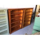 Pair of stained pine open bookcases with solid panelled backs and four fixed shelves on bracket feet