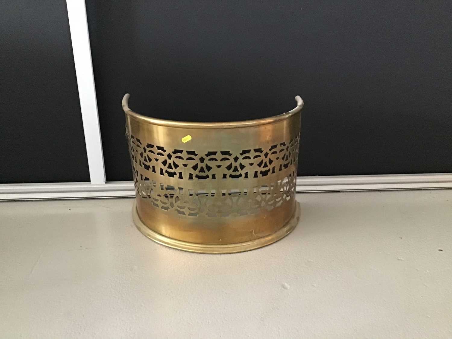 Narrow antique brass fender of bowed form with pierced decoration H36cm W53cm D30cm