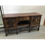 1930's mahogany sideboard with central drawers ant two cupboards either end standing on turned