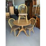 Ercol round breakfast table together with four Ercol stick back chairs, table H73.5cm W100cm