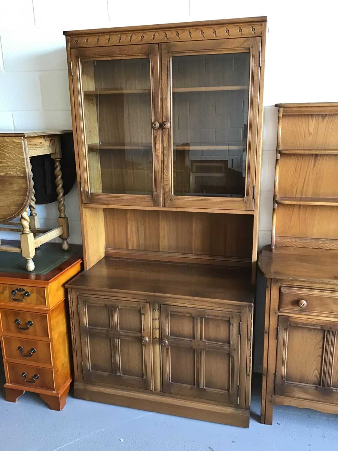 Ercol elm two height bookcase with two glazed doors above enclosing two adjustable shelves, recess t