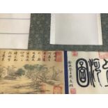 A pair of Chinese table scrolls. Hand coloured printed landscape with calligraphy.