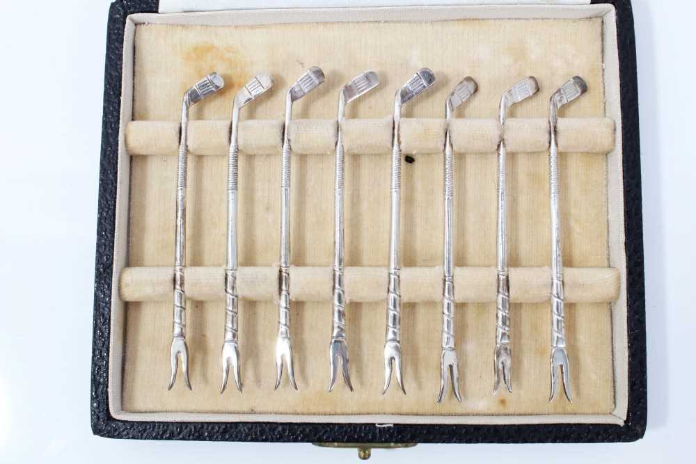 Set of eight silver golf club lobster picks, in fitted case