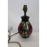 Moorcroft pottery table lamp decorated with a red flower on blue and green ground