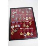 A glass case containing 24 assorted Masonic jewels