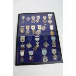 A glass case containing 21 assorted Masonic jewels