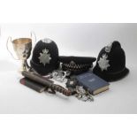 Three Elizabeth II Essex Police hats, together with a pair of hand cuffs, truncheon, badges and othe