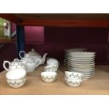 A doll's tea set with tea pot, sugar bowl, milk jug, tea plates and cups and saucers