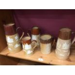 Four Doulton Lambeth stoneware jugs and a similar tankard