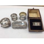Three silver napkin rings, silver trinket box and silver topped cut glass vanity jar