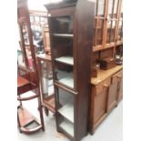 Narrow oak bookcase with shelved interior enclosed by two glazed doors