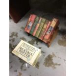 Box set of Beatrix Potter books together with eight other books in an oak book rack