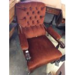 Victorian armchair with button back upholstery, standing on slender turned legs