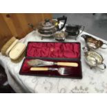 One box containing a selection of silver plated wares including a teaset and a pair of ivory clothes