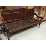18th century oak settle with crossbanded panelled back, scroll arms, solid seat on cabriole legs