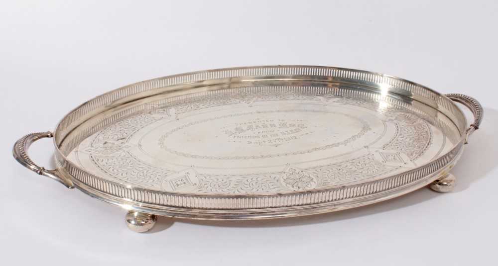 George V silver gallery tray of oval form with engraved foliage decoration and two handles on four b