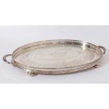 George V silver gallery tray of oval form with engraved foliage decoration and two handles on four b