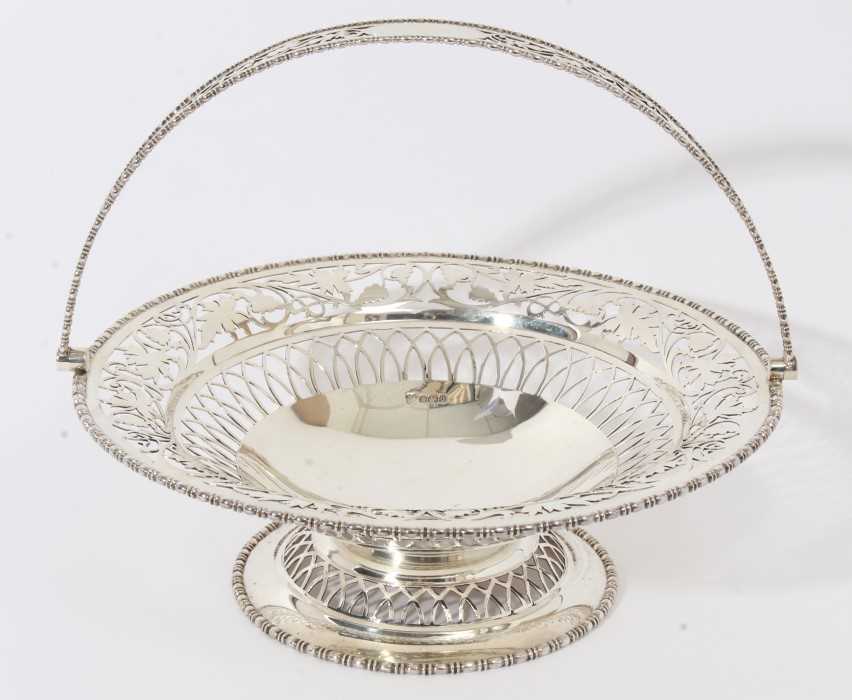 George V silver cake basket of circular form with pierced foliate decoration, egg and dart borders a