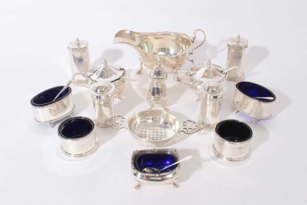 Group of silver condiments to include five salts with blue glass liners, two pairs of pepperettes, p