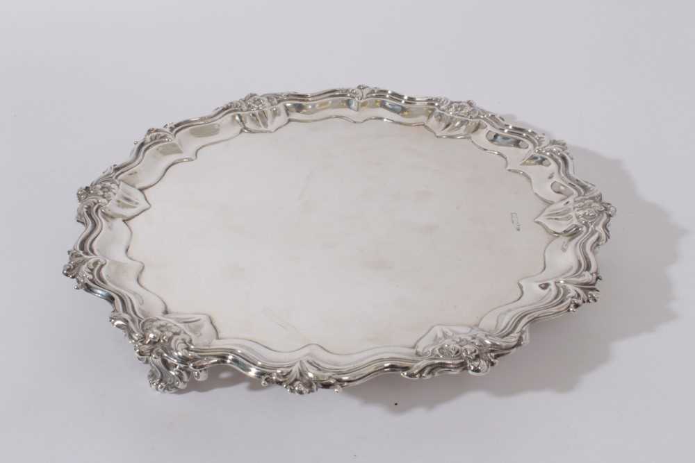 Edwardian silver salver with foliate, floral and scroll border, raised on three scroll feet, (Sheffi