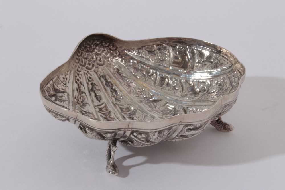 Late 19th / early 20th century Burmese silver dish of shell form, with embossed decoration, raised o