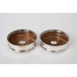 Pair George III silver coasters with gadrooned borders and engraved armorials with wooden bases moun