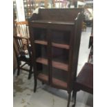 Edwardian oak china display cabinet with scroll carved ledge back, two glazed doors on splayed front