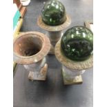 Three cast iron garden urns and two glass witch balls