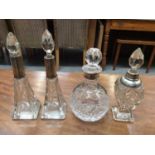 Four silver collared cut glass bottles