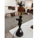 Spelter figural table lamp in the form of a girl playing the flute with amber glass shade