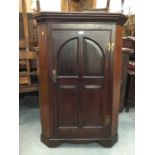 George III oak corner cupboard with ached panelled door enclosing three shaped shelves on bracket fe