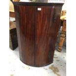 George III inlaid mahogany barrel front hanging corner cupboard with shelved interior