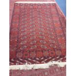 Eastern rug with geometric decoration on red ground, 203cm x 142cm