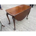 1920's Mahogany oval drop leaf dining table with carved borders and cabriole legs with claw and ball