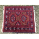 An old Afghan rug on red and blue ground, 104cm x 119cm