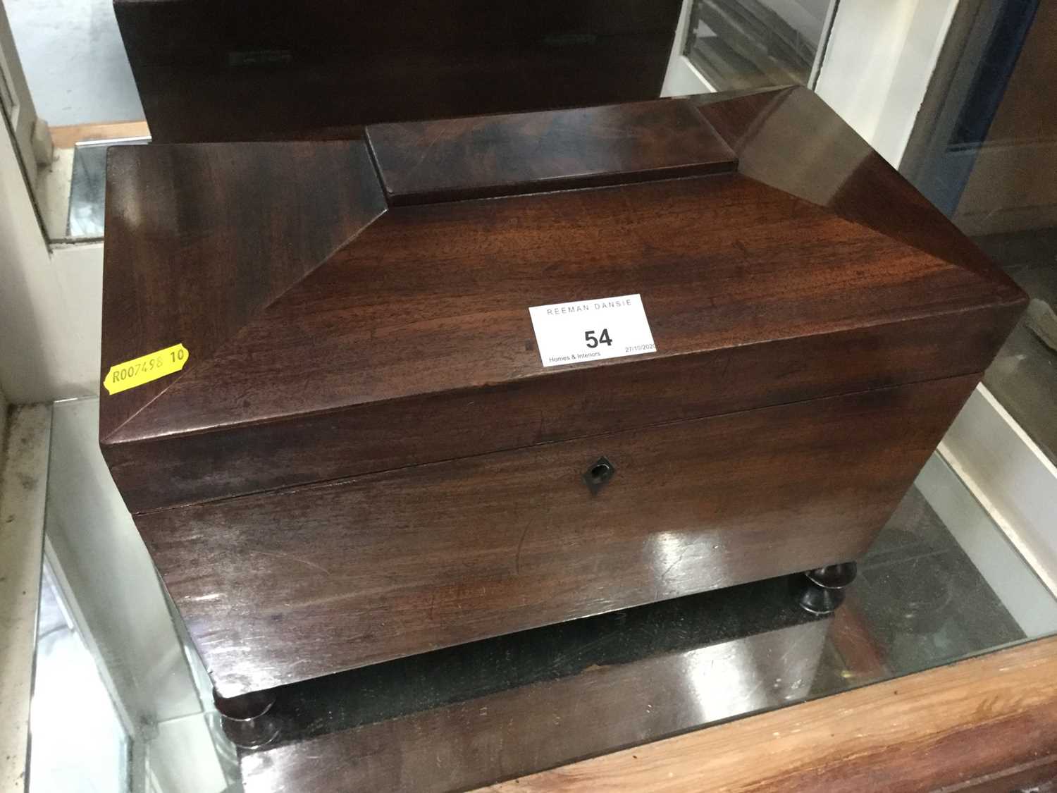 Early Victorian mahogany tea caddy of sarcophagus form with twin tea canisters and mixing well