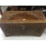 Contemporary Chinese carved camphor wood trunk with decorative figure and landscape panels, on brack