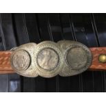 A leather belt with buckle fitted three mounted silver dollars buckle
