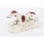 Staffordshire model of a Pointer, c.1830, shown recumbent, front legs crossed, on a stepped base, en