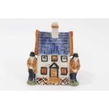 Early 19th century Staffordshire Prattware money box, modelled as a house with figures on either sid