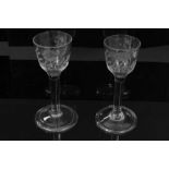 Two Georgian wine glasses, c.1740, the ogee bowls engraved with flowers, with plain stems and folded
