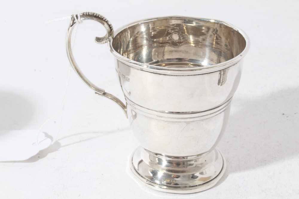 George V silver christening mug of tapered form with central reeded band, with scroll handle, on a c - Image 7 of 11