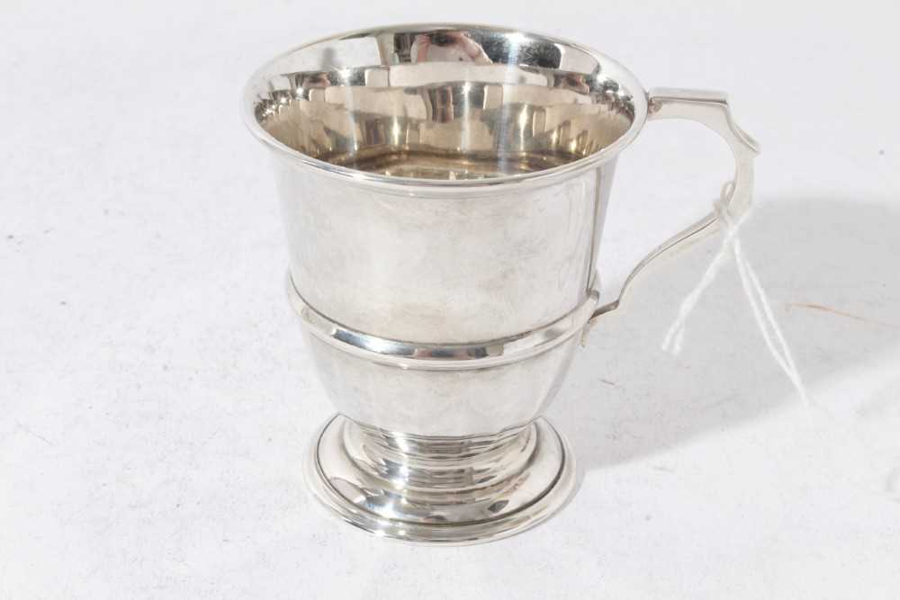 George V silver christening mug of tapered form with central reeded band, with scroll handle, on a c - Image 9 of 11