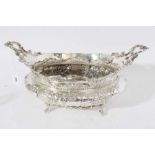 Impressive Edwardian silver table centre bowl of oval form with embossed floral and scroll decoratio