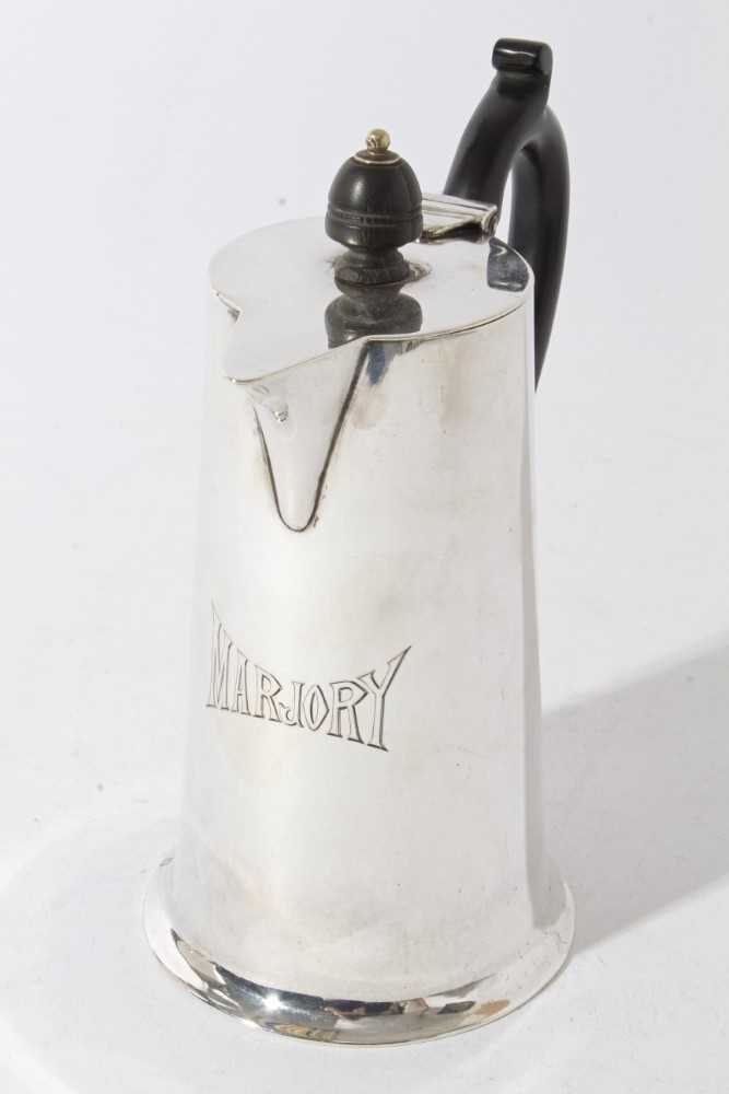 George V Silver hot water pot of tapered form with flared foot, body engraved Marjory, with ebony ha