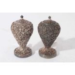 Pair of good quality late 19th century Indian white metal pepperettes of ovoid form with ornate vine